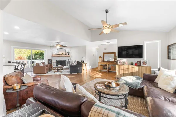 a living room with furniture a flat screen tv and kitchen view