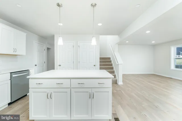 a kitchen with a sink a stove a refrigerator and white cabinets