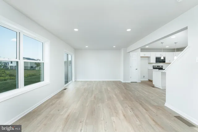 a view of empty room with wooden floor and windows