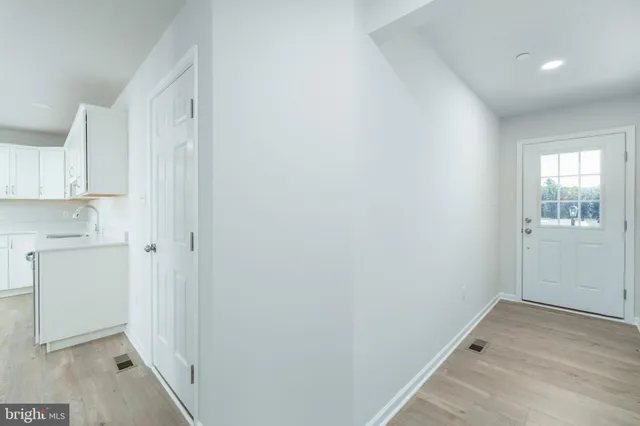 a view of a kitchen with white cabinets and wooden floor