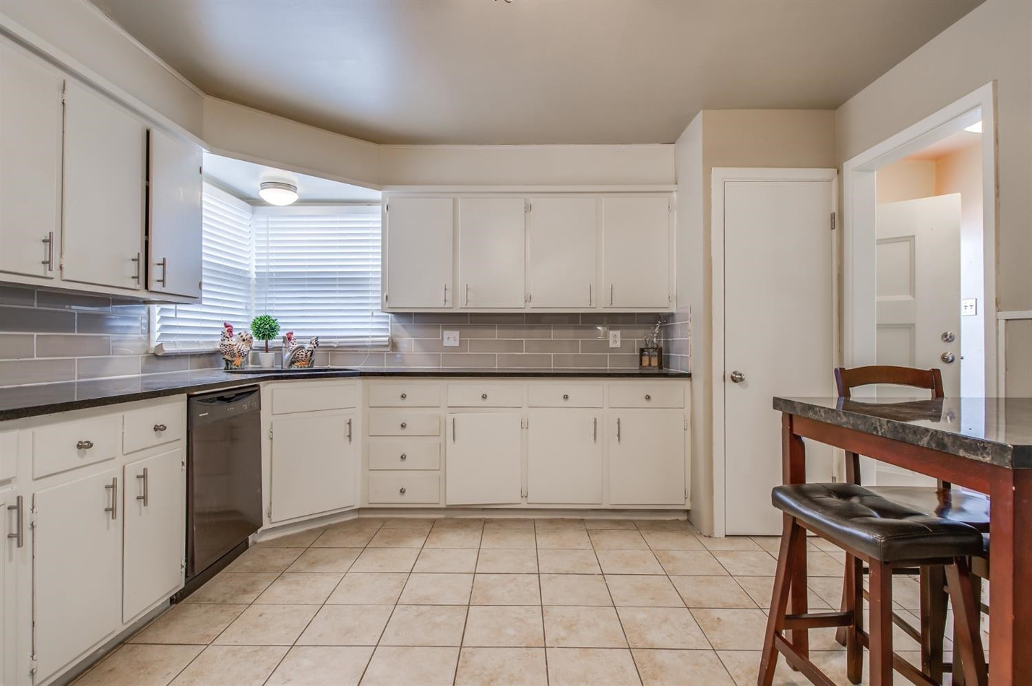 4319 40th Street Lubbock, TX 79413 - Photo 9 of 10 a kitchen with a stove a sink and white cabinets