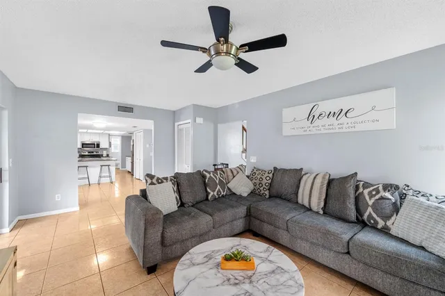a living room with furniture and a view of kitchen