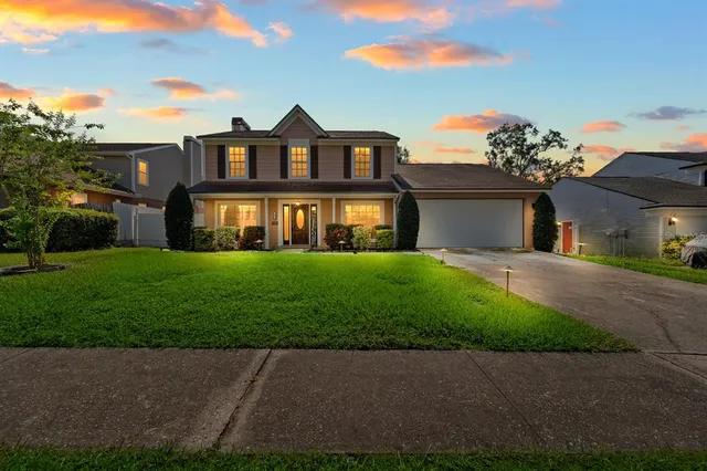 a front view of a house with a garden and yard