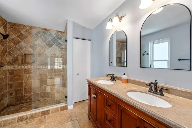a bathroom with a double vanity sink mirror and shower