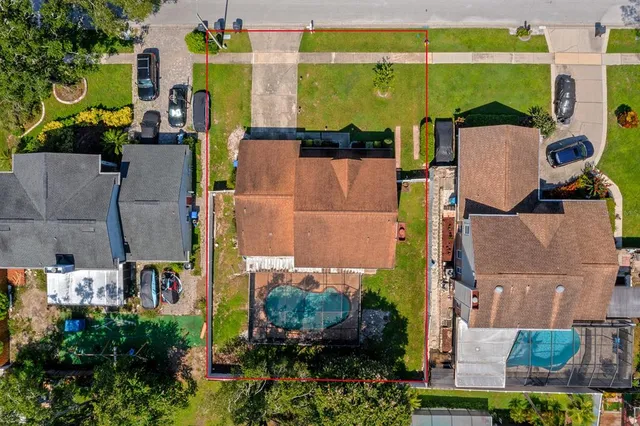 an aerial view of residential houses with outdoor space and parking