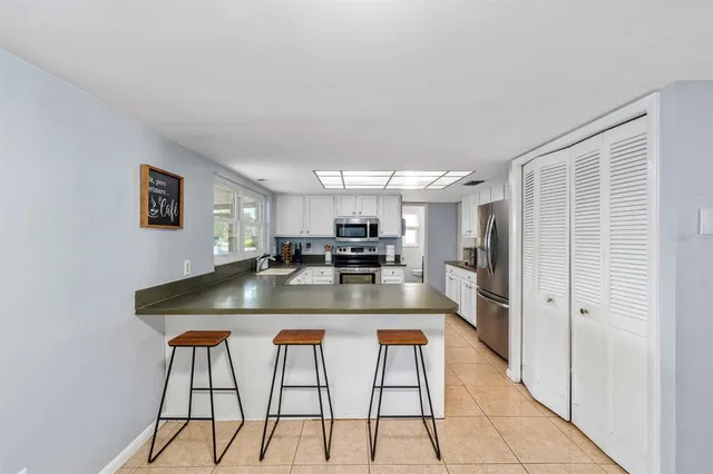 a kitchen with stainless steel appliances granite countertop a sink and a refrigerator