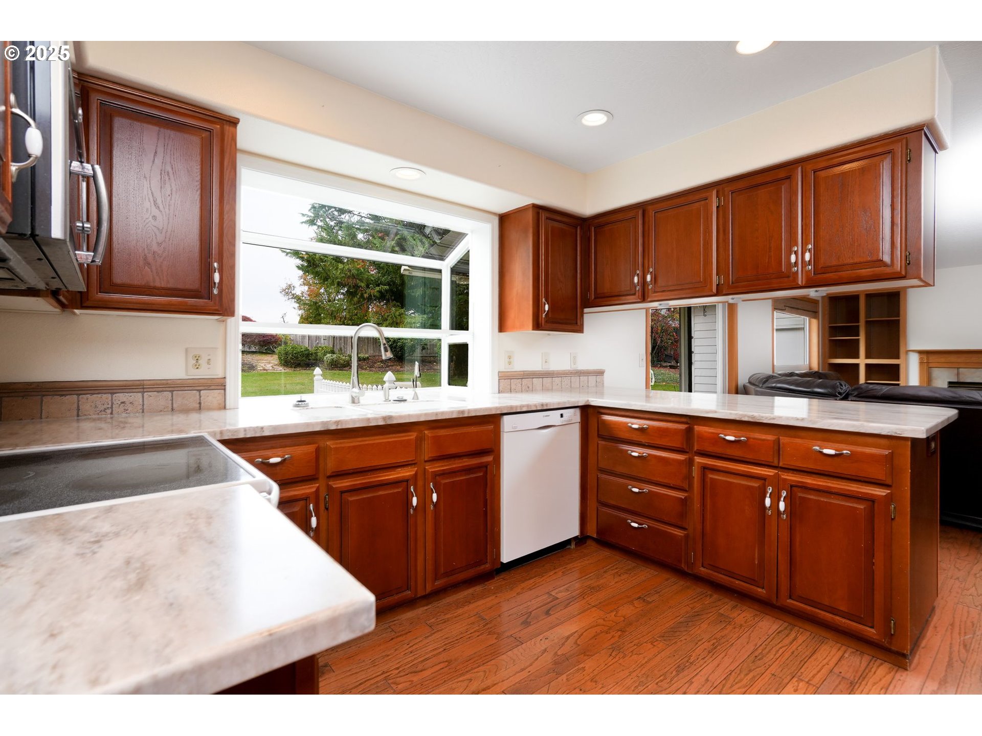503 Southwest Mistmaiden Court Sublimity, OR 97385 - Photo 14 of 47 a kitchen with stainless steel appliances granite countertop wooden cabinets a stove a sink and a large window