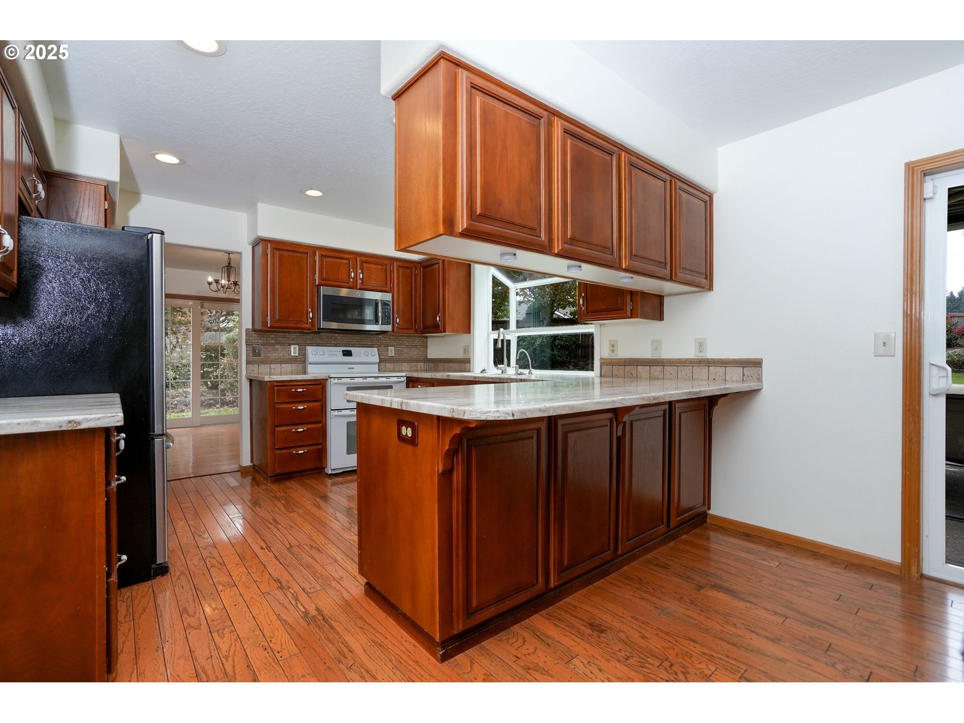 503 Southwest Mistmaiden Court Sublimity, OR 97385 - Photo 17 of 47 a kitchen with stainless steel appliances granite countertop wooden cabinets a stove a sink and a refrigerator