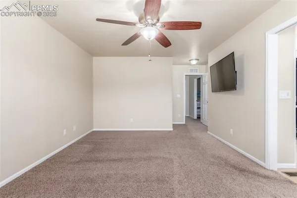a view of an empty room with a ceiling fan
