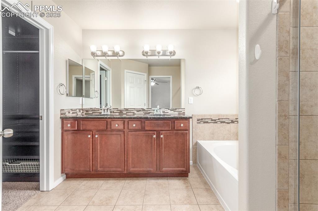 7750 Dutch Loop Colorado Springs, CO 80925 - Photo 15 of 50 a bathroom with a granite countertop sink and a mirror