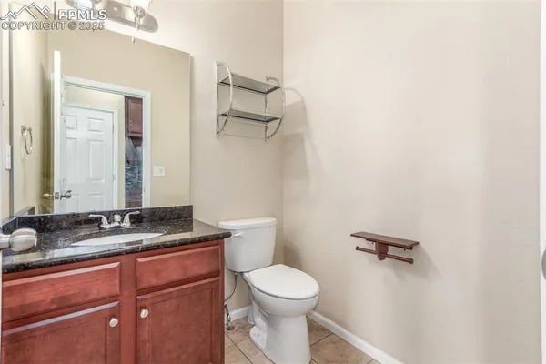 a bathroom with a granite countertop sink mirror vanity and toilet