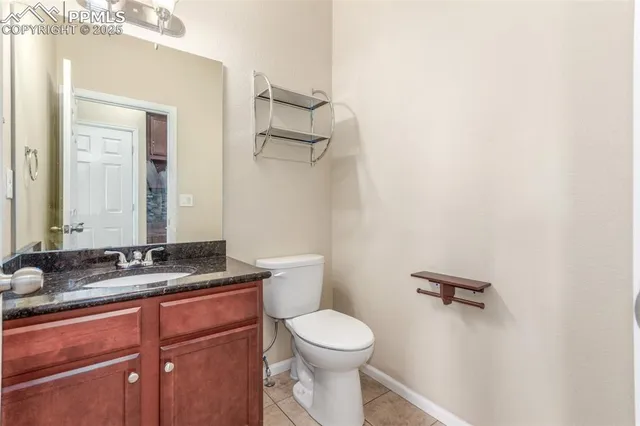 a bathroom with a granite countertop sink mirror vanity and toilet