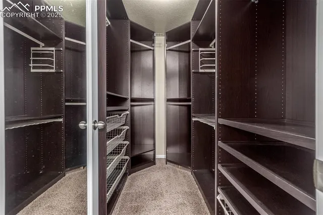 a view of walk in closet with clothes and shoes