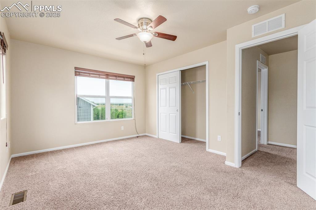 7750 Dutch Loop Colorado Springs, CO 80925 - Photo 20 of 50 an empty room with chandelier fan and windows
