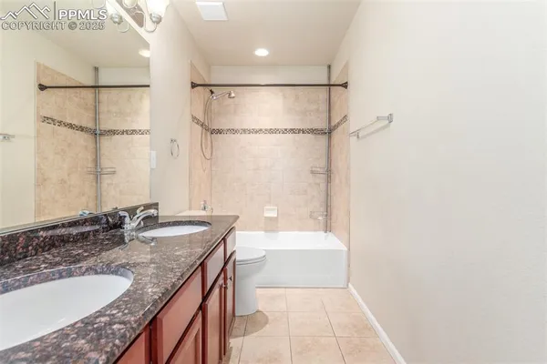 a bathroom with a granite countertop sink a mirror and shower