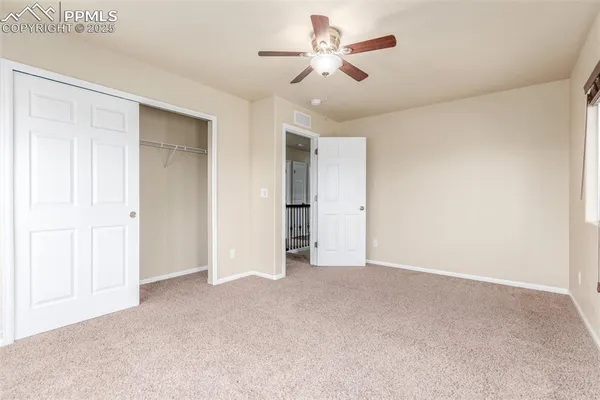 a view of an empty room and a ceiling fan