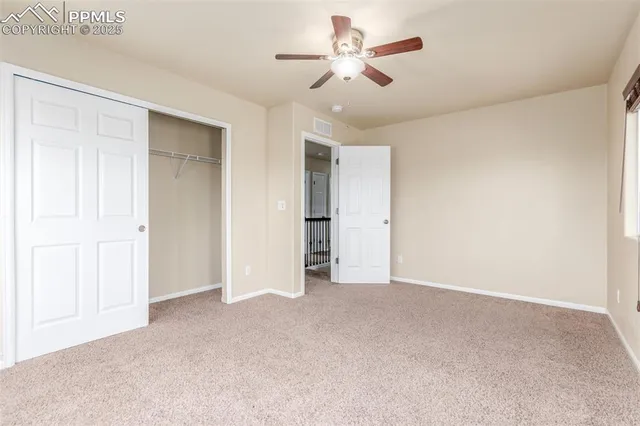 a view of an empty room and a ceiling fan