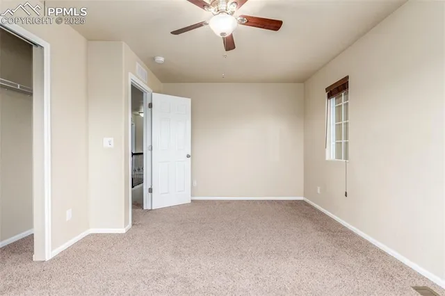 a view of an empty room with a ceiling fan