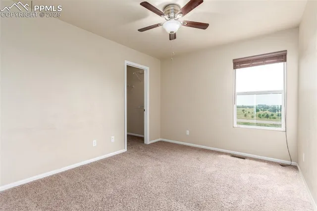 an empty room with a window and a fan