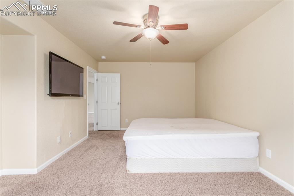 7750 Dutch Loop Colorado Springs, CO 80925 - Photo 38 of 50 a bedroom with a bed and a flat screen tv