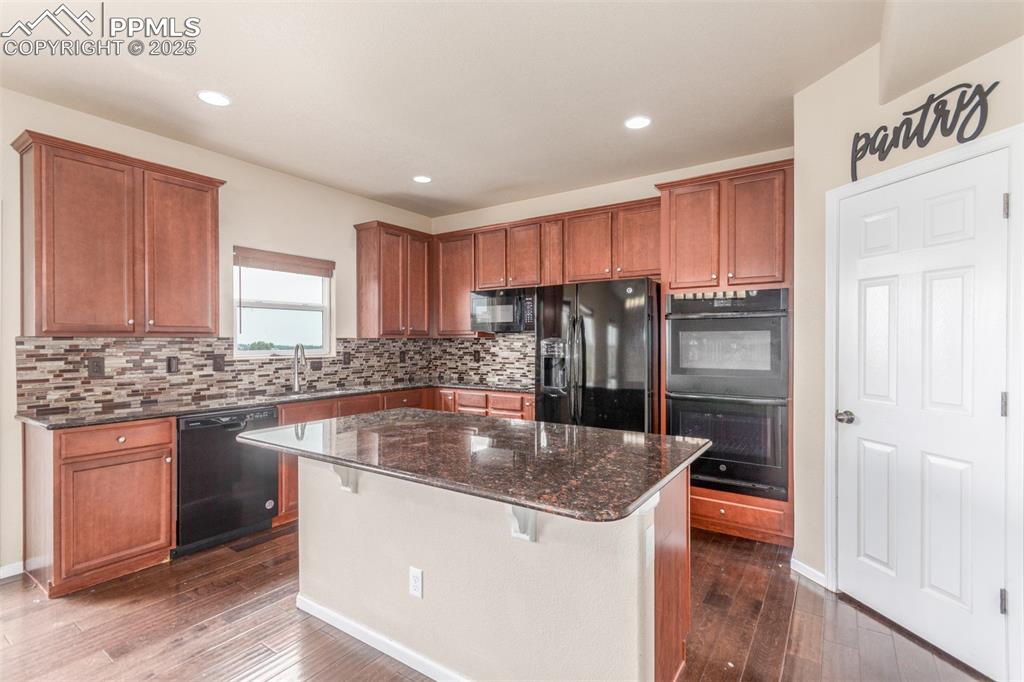 7750 Dutch Loop Colorado Springs, CO 80925 - Photo 5 of 50 a kitchen with stainless steel appliances granite countertop a sink a stove and a refrigerator