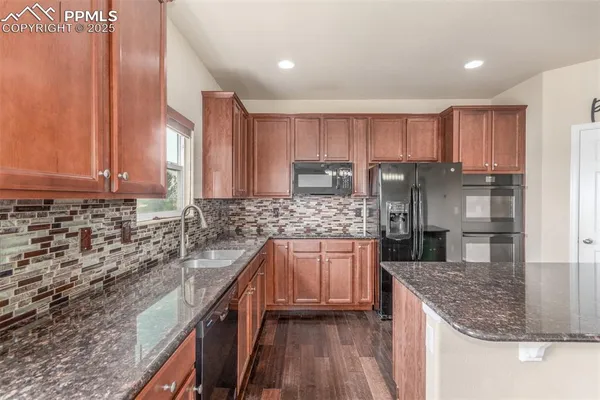 a kitchen with stainless steel appliances granite countertop a sink stove and cabinets