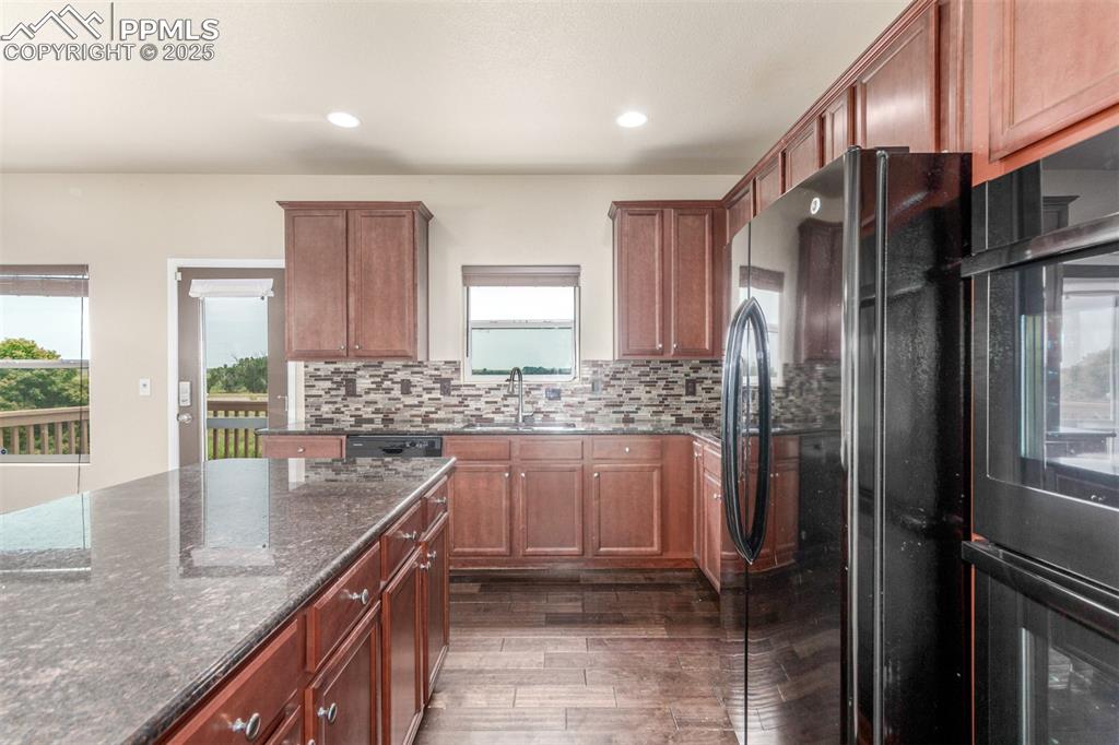 7750 Dutch Loop Colorado Springs, CO 80925 - Photo 8 of 50 a kitchen with stainless steel appliances granite countertop a sink a stove and a refrigerator