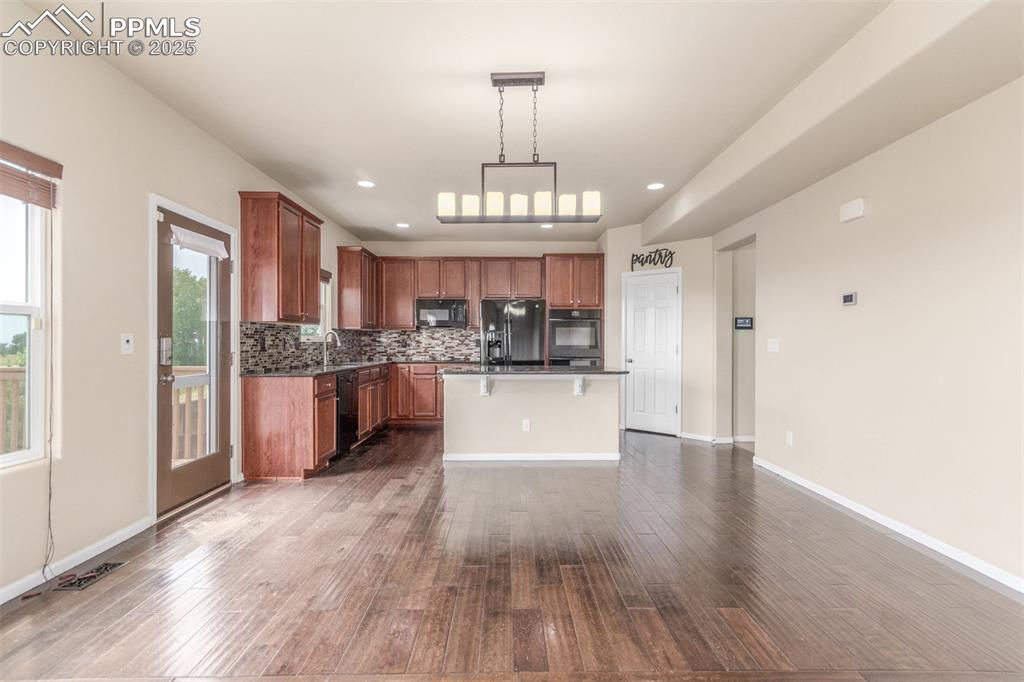 7750 Dutch Loop Colorado Springs, CO 80925 - Photo 9 of 50 a view of a kitchen with cabinets and wooden floor