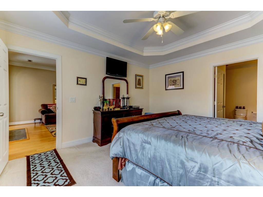 217 Eva Drive Gibsonville, NC 27249 - Photo 16 of 24 a bedroom with a bed and a chandelier