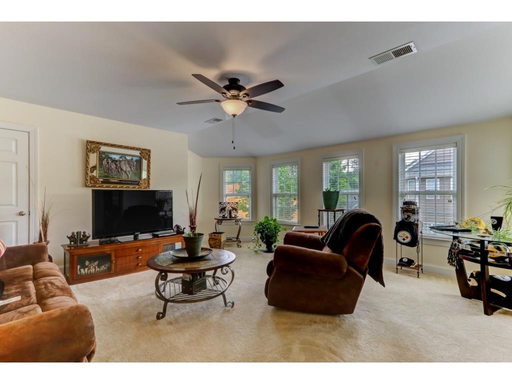 217 Eva Drive Gibsonville, NC 27249 - Photo 18 of 24 a living room with furniture a flat screen tv and a large window