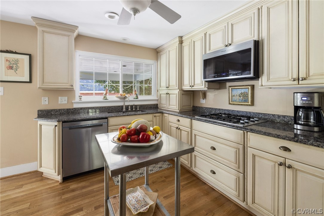 7658 Cherokee Road Richmond, VA 23225 - Photo 15 of 36 a kitchen with stainless steel appliances kitchen island granite countertop a stove a sink and a microwave