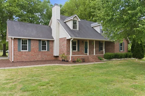 a front view of a house with a garden and yard