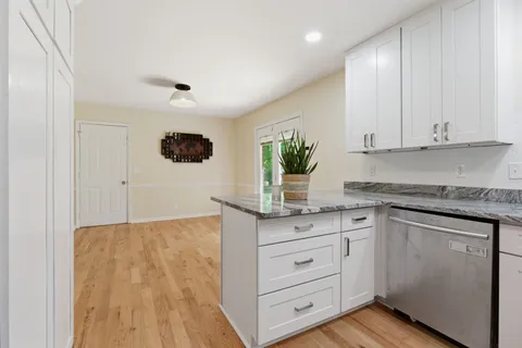 a kitchen with granite countertop white cabinets and white appliances