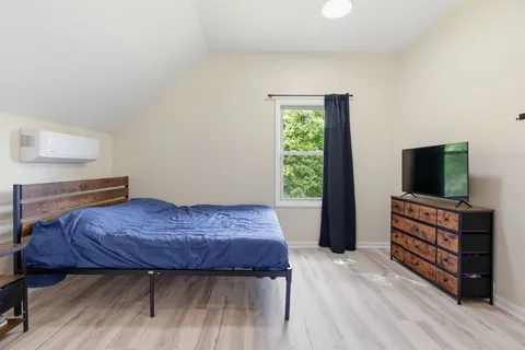 a bedroom with a bed and a flat screen tv