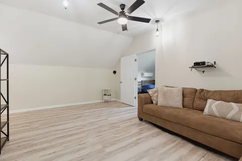 a living room with furniture and a ceiling fan