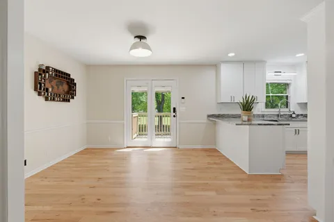 a kitchen with stainless steel appliances granite countertop a stove a sink and a refrigerator with white cabinets