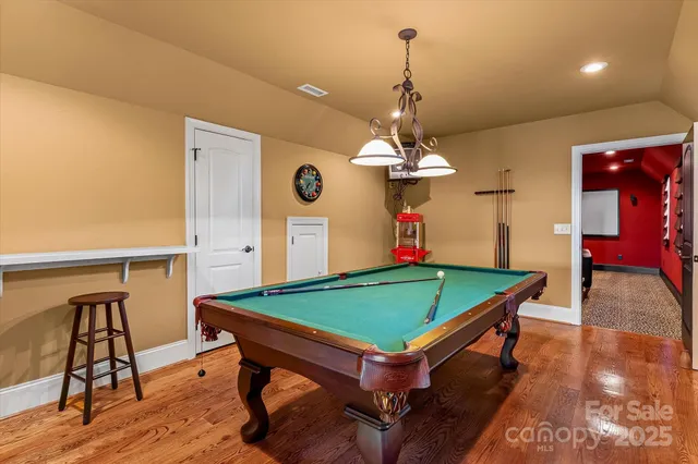 a room with pool table and wooden floor
