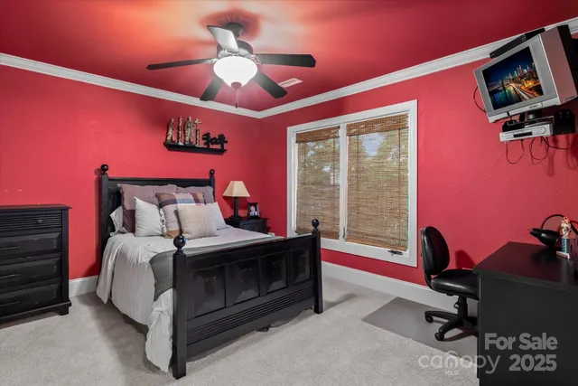 a bed sitting in a spacious bedroom next to a window