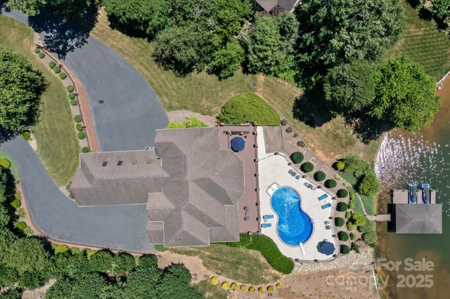 an aerial view of a house with a yard and large trees