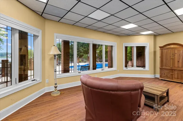 a spacious bedroom with wooden floor and large windows