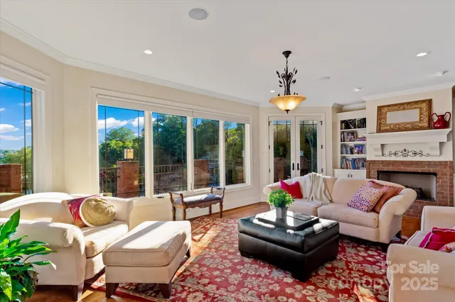 a living room with furniture fireplace and large windows