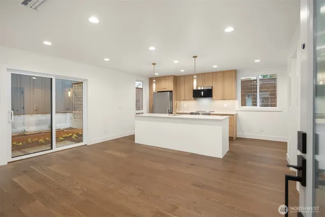 a large kitchen with stainless steel appliances granite countertop a large window and a refrigerator