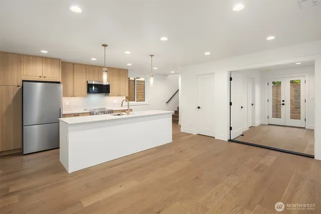 a view of kitchen with stainless steel appliances kitchen island a refrigerator and a stove top oven