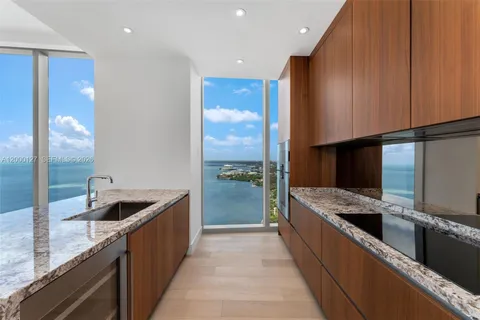 a kitchen with stainless steel appliances granite countertop a sink and a refrigerator