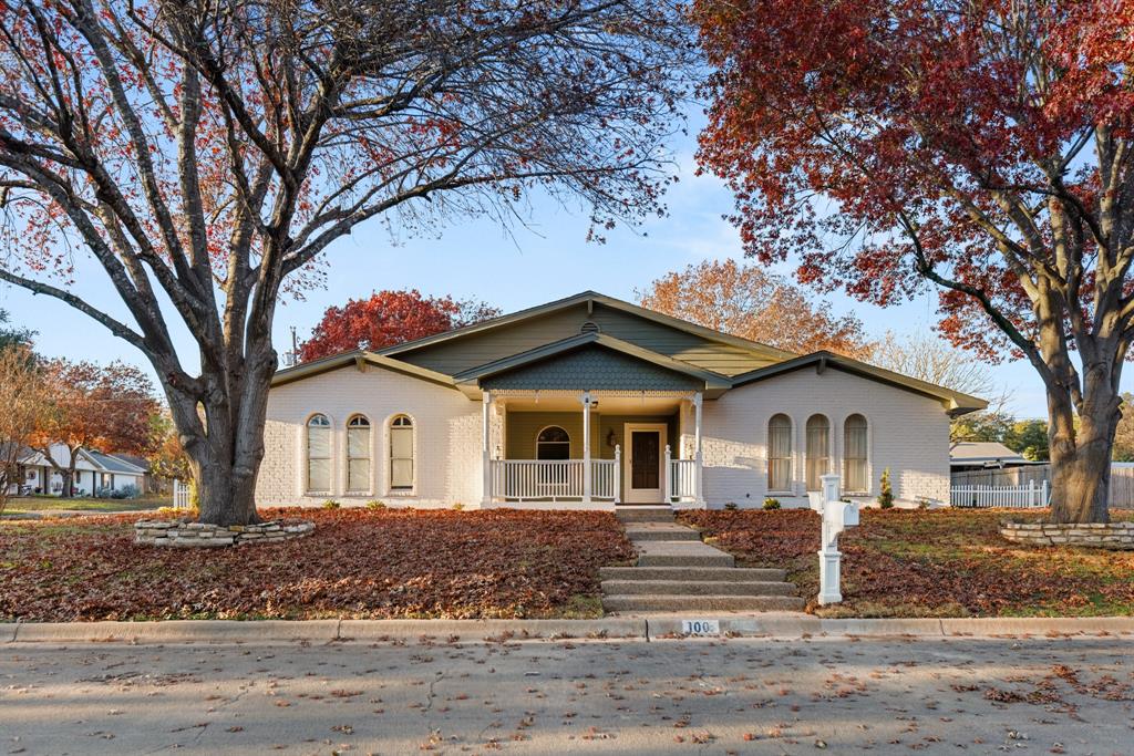 a white house that has a tree in front of it