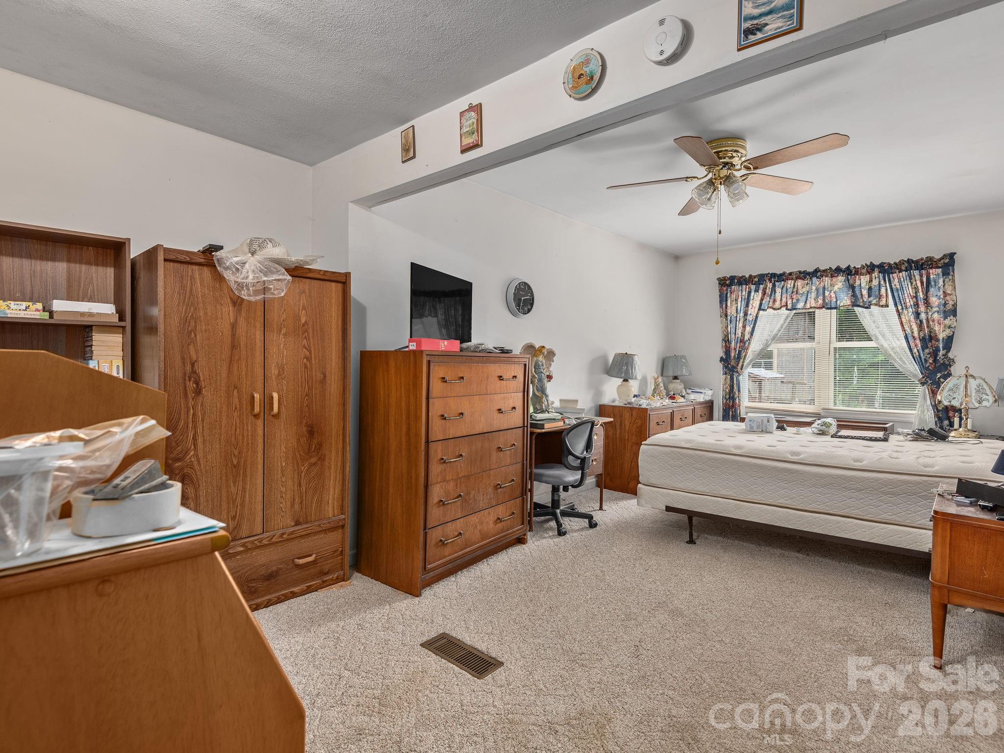 379 North Fork Road Barnardsville, NC 28709 - Photo 11 of 27 a bedroom with furniture and a chandelier