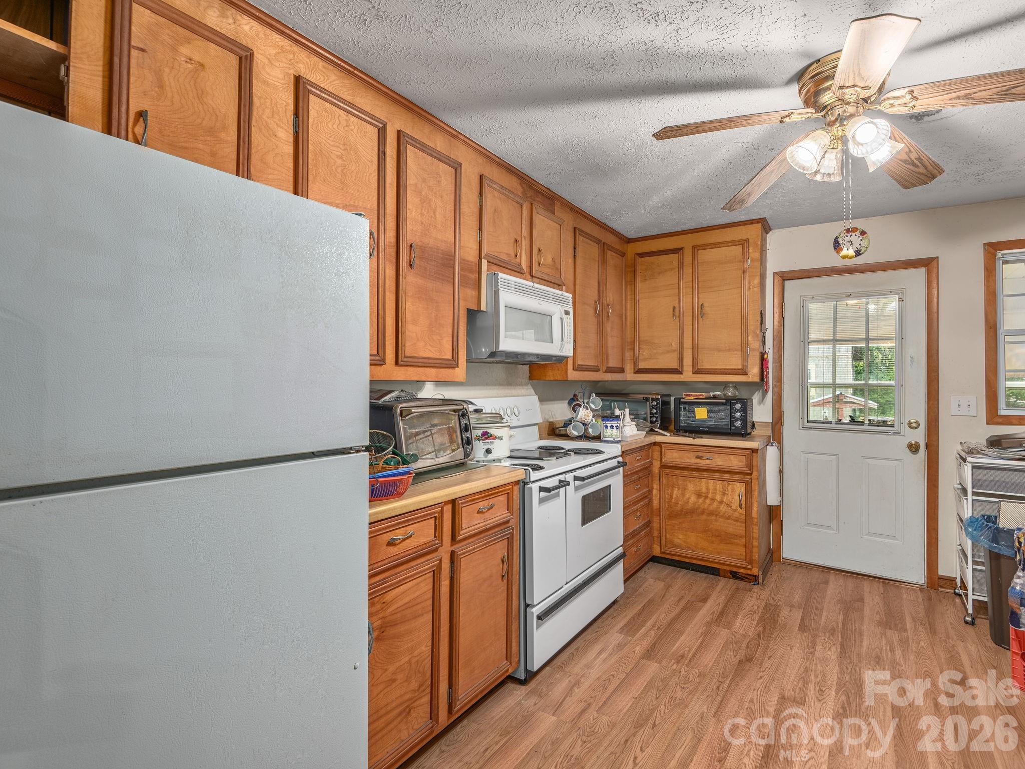 379 North Fork Road Barnardsville, NC 28709 - Photo 8 of 27 a kitchen with stainless steel appliances granite countertop a refrigerator a sink dishwasher a stove with wooden cabinets and floors