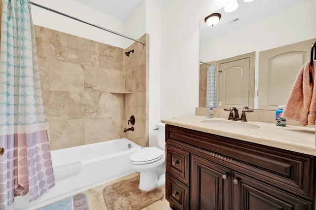 a spacious bathroom with a granite countertop sink a mirror a shower and a bathtub
