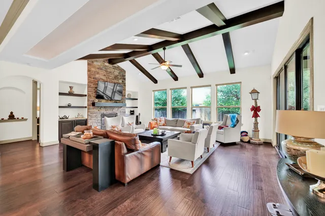 a living room with fireplace furniture and a large window
