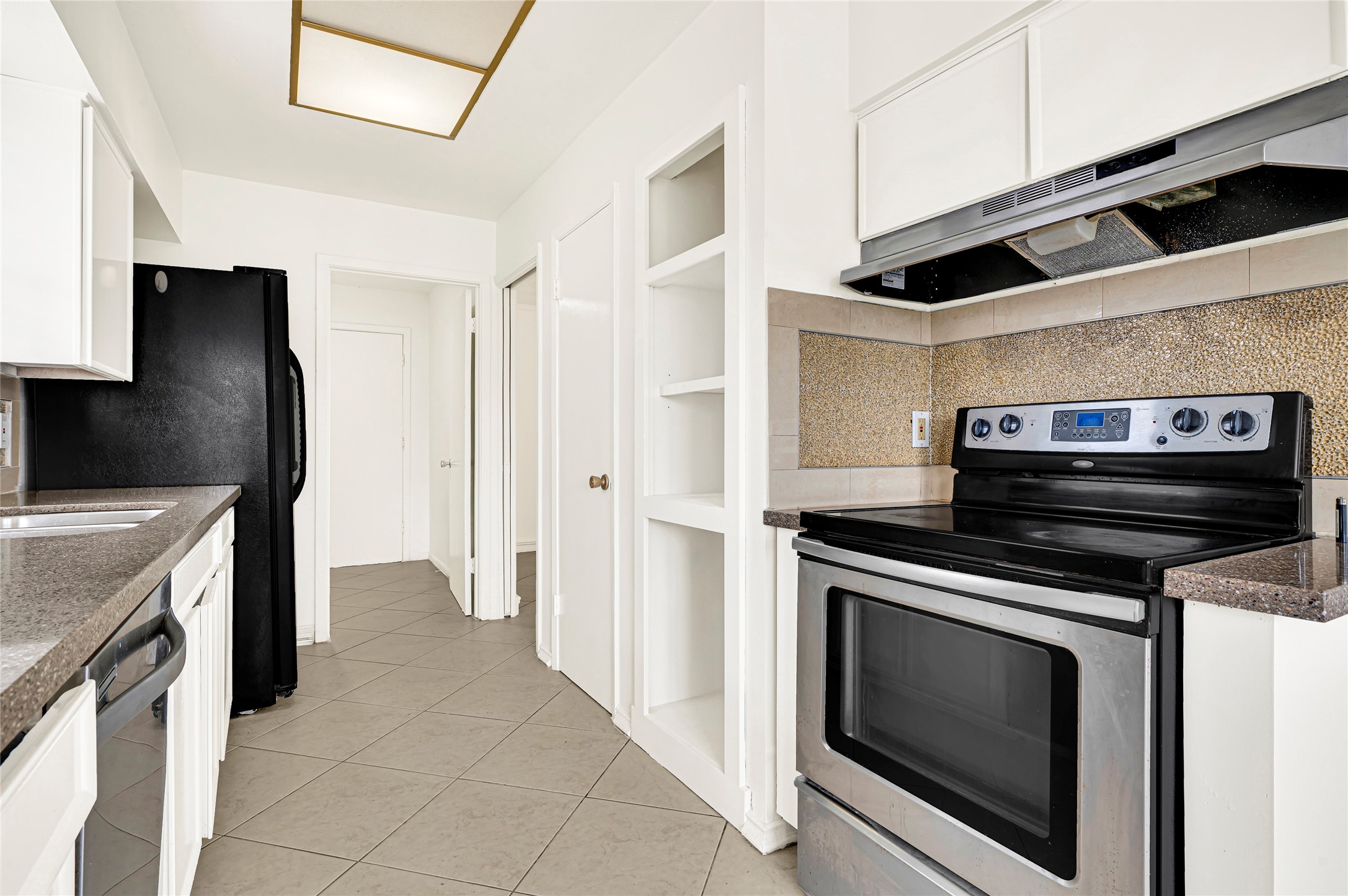 7302 Redding Road Houston, TX 77036 - Photo 22 of 26 a kitchen with stainless steel appliances kitchen island a stove and a refrigerator